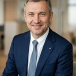 Профессиональный портрет Юрия Роста: уверенный бизнесмен с дружелюбным взглядом на нейтральном студийном фоне